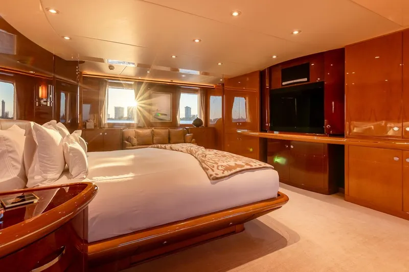 Mystique Yacht Photos Pics Luxurious bedroom interior on 2001 Feadship Custom yacht with elegant wood finishes and large windows.