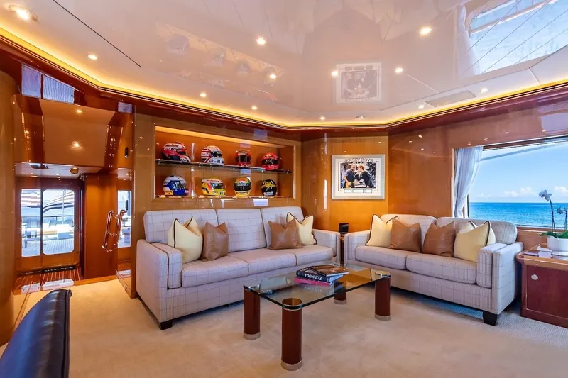 Mystique Yacht Photos Pics Luxurious yacht interior with plush seating, racing helmets display, and ocean view. Feadship Custom 2001.