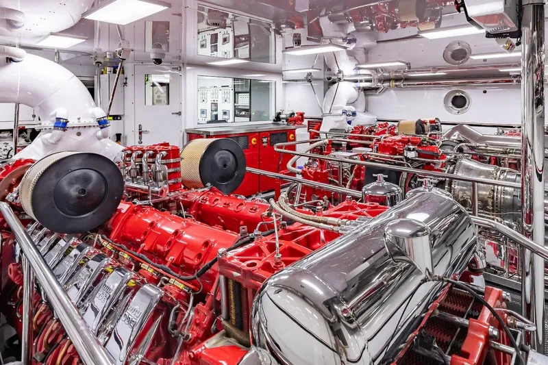 Mystique Yacht Photos Pics Engine room of a 2001 Feadship Custom yacht, featuring red machinery and polished metal components.