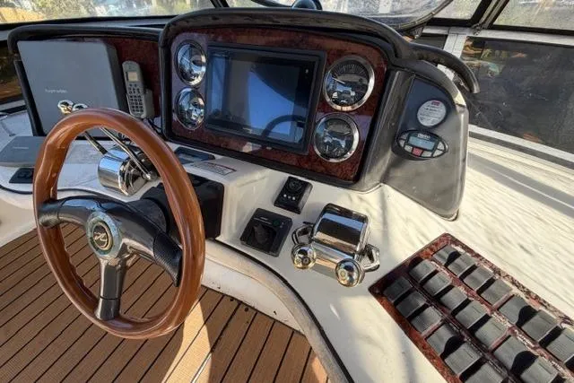 Big Energy Yacht Photos Pics 2004 Sea Ray 420 Sedan Bridge helm with wood accents and modern controls.