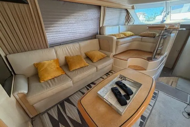 Big Energy Yacht Photos Pics Luxurious interior of a 2004 Sea Ray 420 Sedan Bridge yacht with beige seating and yellow cushions.