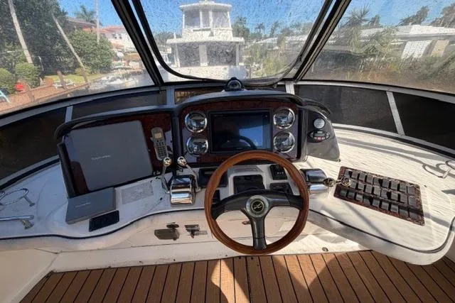 Big Energy Yacht Photos Pics 2004 Sea Ray 420 Sedan Bridge helm with wooden steering wheel and navigation controls.