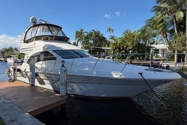 Big Energy Yacht Photos Pics 2004 Sea Ray 420 Sedan Bridge yacht docked by palm trees under blue sky.