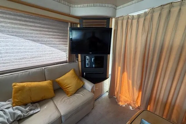 Big Energy Yacht Photos Pics Interior of 2004 Sea Ray 420 Sedan Bridge with TV, sofa, and curtains.