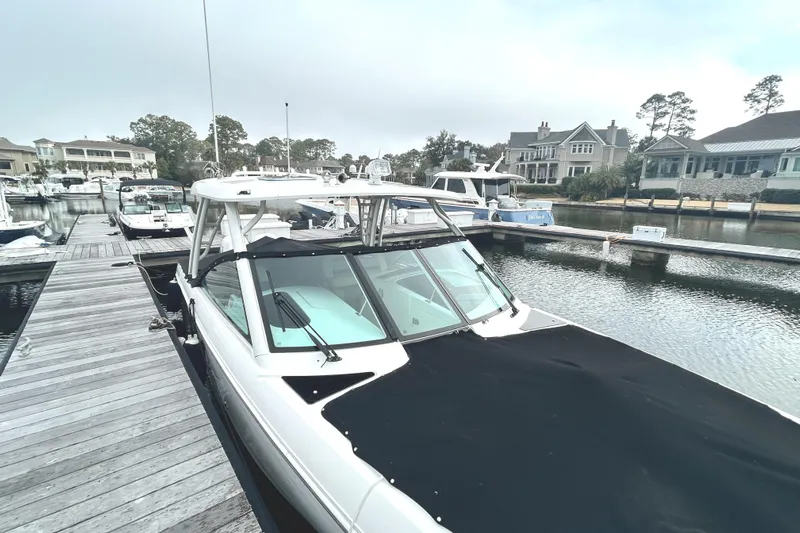  Yacht Photos Pics 2017 Boston Whaler 320 Vantage docked at a marina, surrounded by other boats.