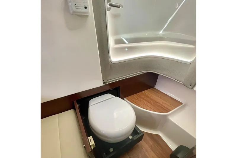 Seaventure Yacht Photos Pics 2023 Chaparral 280 OSX boat interior with compact bathroom and wooden flooring.