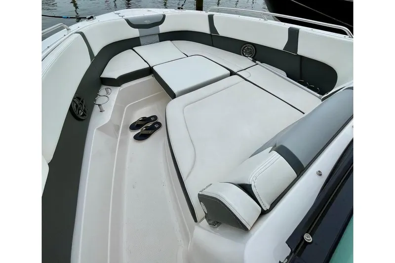 Seaventure Yacht Photos Pics 2023 Chaparral 280 OSX boat interior with seating and flip-flops, docked at marina.