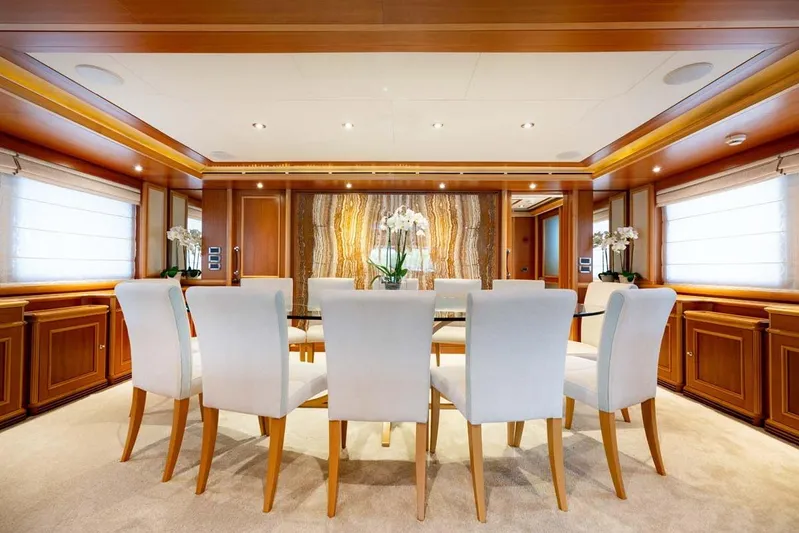 Emotion 2 Yacht Photos Pics Luxurious dining area on a 2007 CRN Motor Yacht with elegant wood paneling and white chairs.