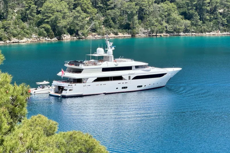 Emotion 2 Yacht Photos Pics Luxurious 2007 CRN Motor Yacht anchored in serene turquoise waters, surrounded by lush greenery.