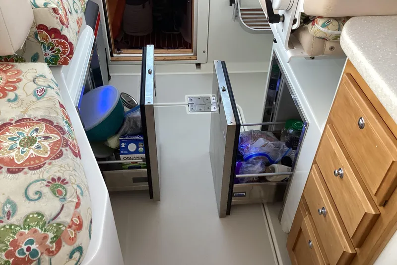 Ha Kin Yacht Photos Pics Interior of a 2008 Back Cove 33 boat with open storage drawers and floral seating.