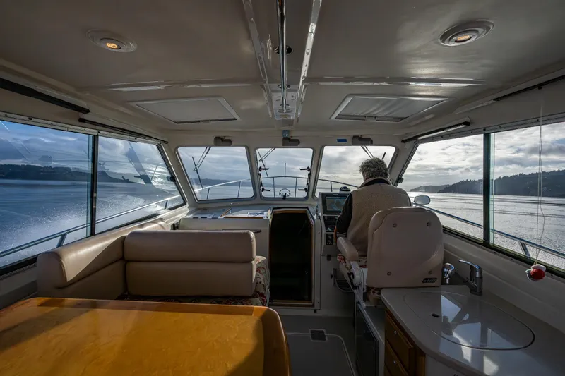 Ha Kin Yacht Photos Pics Interior view of 2008 Back Cove 33 boat with person navigating on a sunny day.