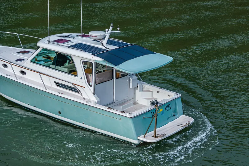 Ha Kin Yacht Photos Pics 2008 Back Cove 33 boat cruising on water with solar panels on roof.