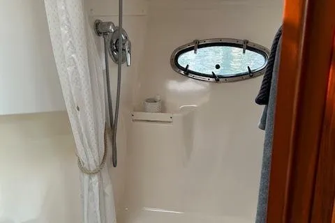 Yacht Photos Pics Shower area in 2000 Tiara Yachts 3700 Open, featuring a porthole and curtain.