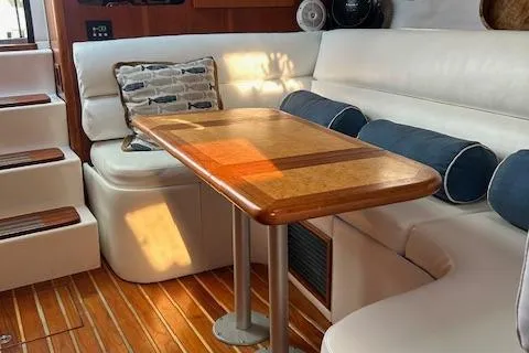  Yacht Photos Pics Interior of 2000 Tiara Yachts 3700 Open with wooden table and white seating.