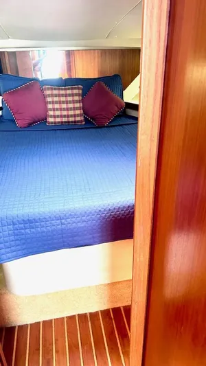  Yacht Photos Pics 2000 Tiara Yachts 3700 Open cabin with blue bedding and decorative pillows.