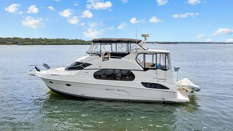 Sunset Chaser Yacht Photos Pics 2002 Silverton 43 Motor Yacht on calm water under blue sky.