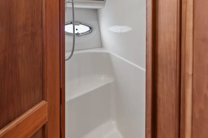 Sunset Chaser Yacht Photos Pics 2002 Silverton 43 Motor Yacht shower interior with wooden door and porthole window.