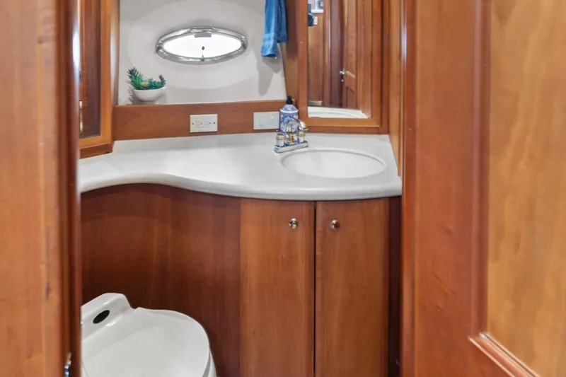 Sunset Chaser Yacht Photos Pics 2002 Silverton 43 Motor Yacht bathroom with wooden cabinetry and modern fixtures.