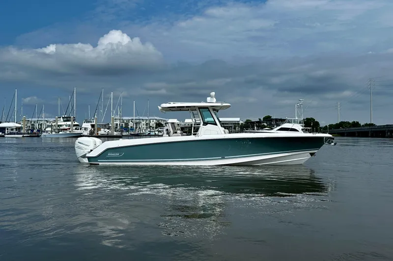 Bottoms Up Yacht Photos Pics 2019 Boston Whaler 330 Outrage boat on calm water, marina in background.