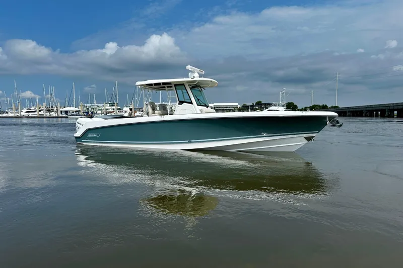 Bottoms Up Yacht Photos Pics 2019 Boston Whaler 330 Outrage boat on calm water, marina in background.