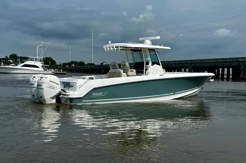Bottoms Up Yacht Photos Pics 2019 Boston Whaler 330 Outrage boat on calm water, under cloudy sky.