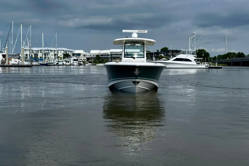 Bottoms Up Yacht Photos Pics 2019 Boston Whaler 330 Outrage boat on calm water, marina background, overcast sky.