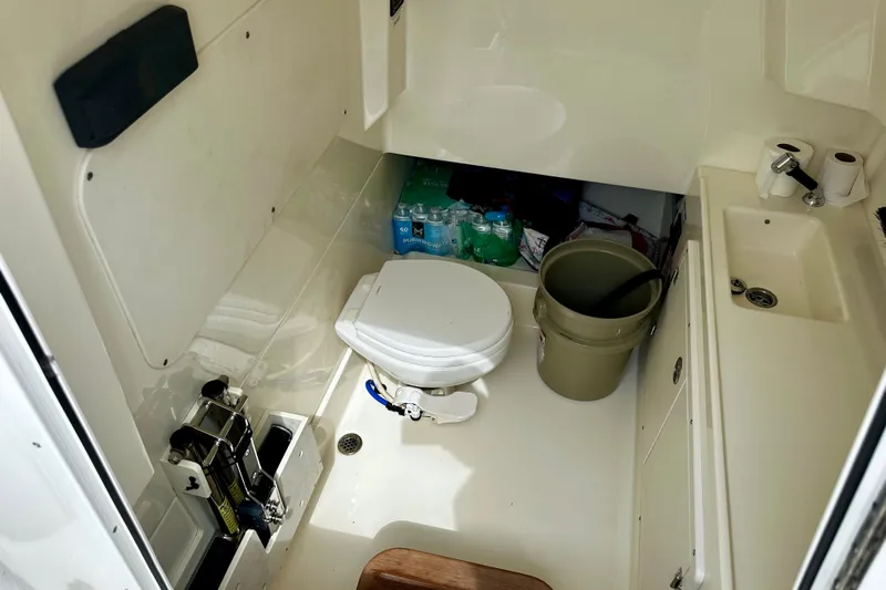 Bottoms Up Yacht Photos Pics 2019 Boston Whaler 330 Outrage interior with toilet, sink, and storage area.