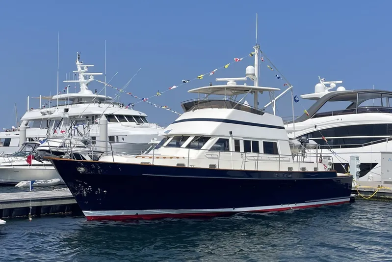 Blue Glass Yacht Photos Pics 1986 Custom C. Raymond Hunt Design Yacht docked, surrounded by other luxury boats, under clear blue sky.
