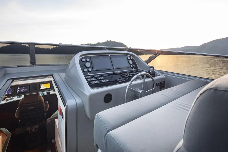  Yacht Photos Pics Helm of 2009 Canados 110 yacht with modern controls, overlooking serene waters at sunset.