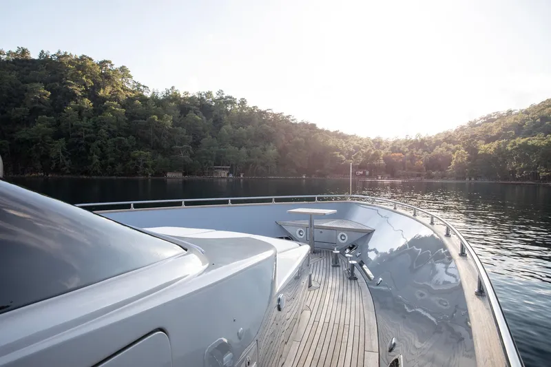  Yacht Photos Pics Luxurious 2009 Canados 110 yacht cruising on serene waters near lush green hills.