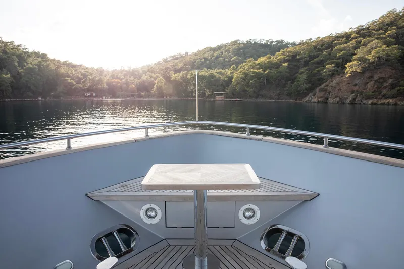  Yacht Photos Pics Bow view of 2009 Canados 110 yacht with serene water and lush hills.