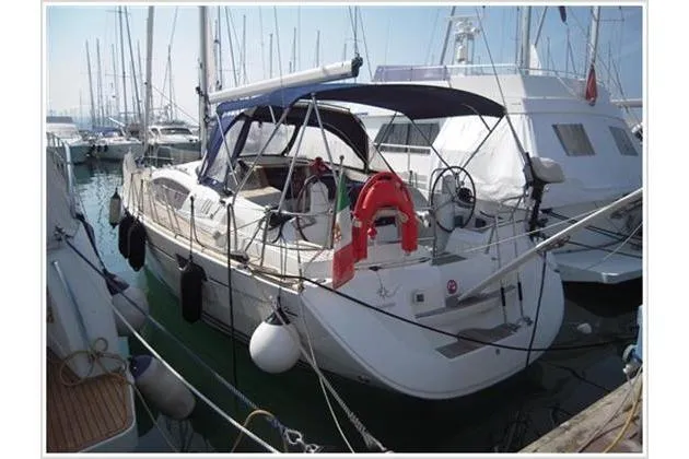  Yacht Photos Pics 2010 Jeanneau Sun Odyssey 42 DS sailboat docked in marina, featuring spacious deck and canopy.