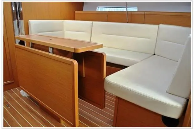  Yacht Photos Pics Interior of 2010 Jeanneau Sun Odyssey 42 DS with wooden table and white seating.