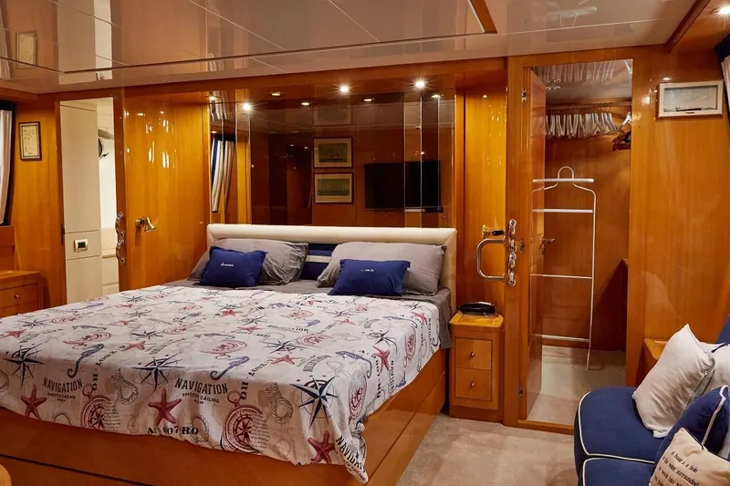 Kinglass VI Yacht Photos Pics Luxurious bedroom interior of 1999 Sanlorenzo SL82 yacht with nautical-themed bedding.