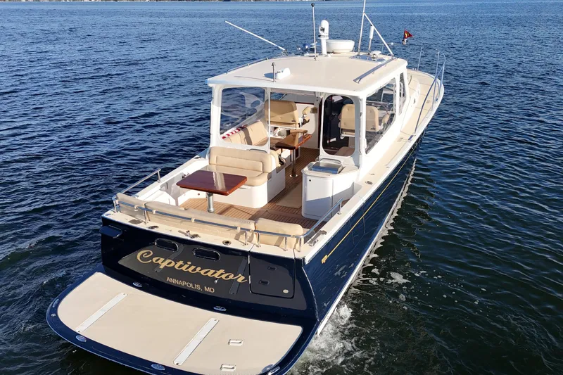 Captivator Yacht Photos Pics 2017 MJM 40z Downeast yacht cruising on open water, rear view.