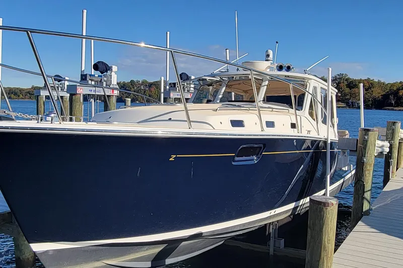 Captivator Yacht Photos Pics 2017 MJM 40z Downeast boat docked by the water on a sunny day.
