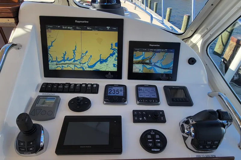 Captivator Yacht Photos Pics Control panel of a 2017 MJM 40z Downeast boat with navigation screens and controls.