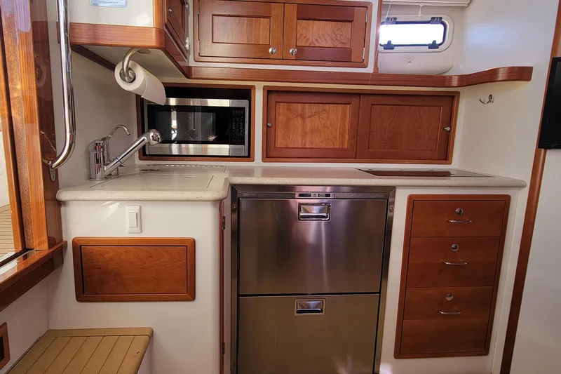 Captivator Yacht Photos Pics 2017 MJM 40z Downeast yacht kitchen with wood cabinets, stainless appliances, and modern fixtures.
