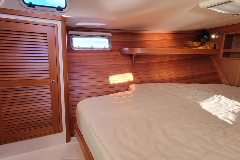 Captivator Yacht Photos Pics 2017 MJM 40z Downeast cabin interior with wooden paneling and cozy bed.