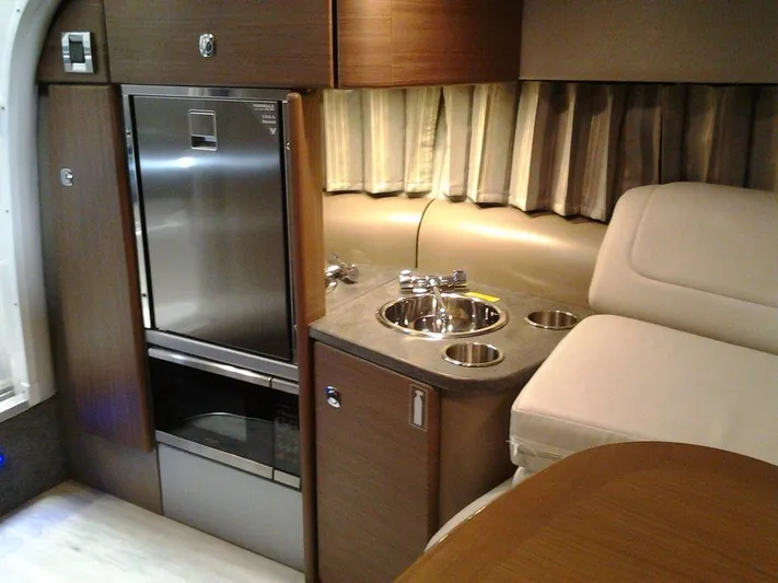  Yacht Photos Pics 2018 Formula 310 Sun Sport interior with kitchenette, featuring sink, fridge, and seating area.