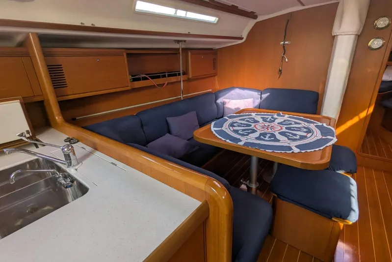  Yacht Photos Pics Interior of 2006 Grand Soleil 50 yacht with cozy seating and nautical-themed table.