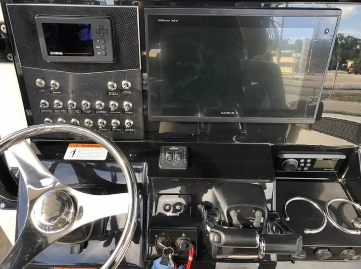  Yacht Photos Pics 2018 Wellcraft 302 Fisherman dashboard with steering wheel, controls, and Garmin display.