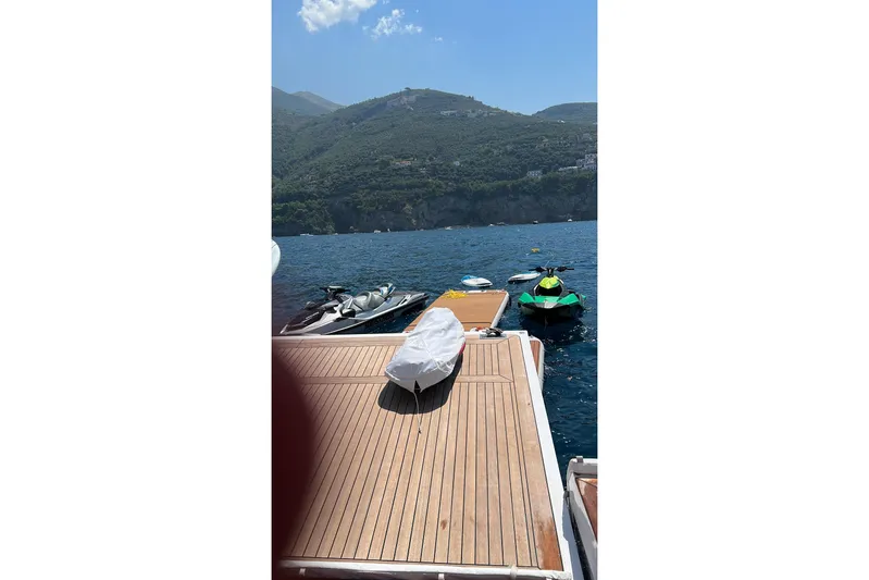 Dagusha Yacht Photos Pics Azimut Grande 35 Metri yacht deck with jet skis on a scenic coastal backdrop.