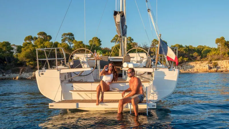  Yacht Photos Pics Couple relaxing on a 2025 Hanse 410 sailboat in sunny coastal waters.