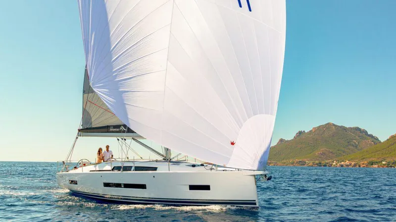  Yacht Photos Pics 2025 Hanse 410 sailboat cruising on open water with scenic coastal backdrop.