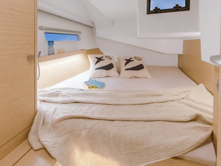  Yacht Photos Pics Cozy cabin interior of 2025 Hanse 410 yacht with bed and decorative pillows.