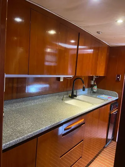 New Beginning Yacht Photos Pics Luxurious Cheoy Lee 75 yacht kitchen with sleek wood cabinetry and modern fixtures, 1990 model.