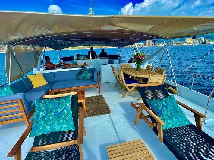 New Beginning Yacht Photos Pics Luxurious 1990 Cheoy Lee 75 yacht deck with seating, dining area, and ocean view.