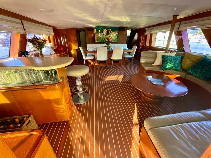 New Beginning Yacht Photos Pics Luxurious interior of a 1990 Cheoy Lee 75 yacht with elegant seating and dining area.