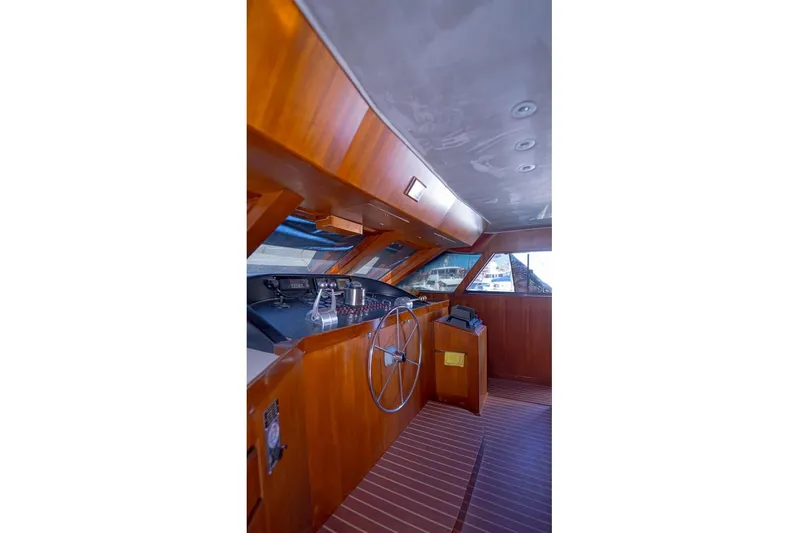 New Beginning Yacht Photos Pics Interior helm of 1990 Cheoy Lee 75 yacht with wooden finish and steering wheel.